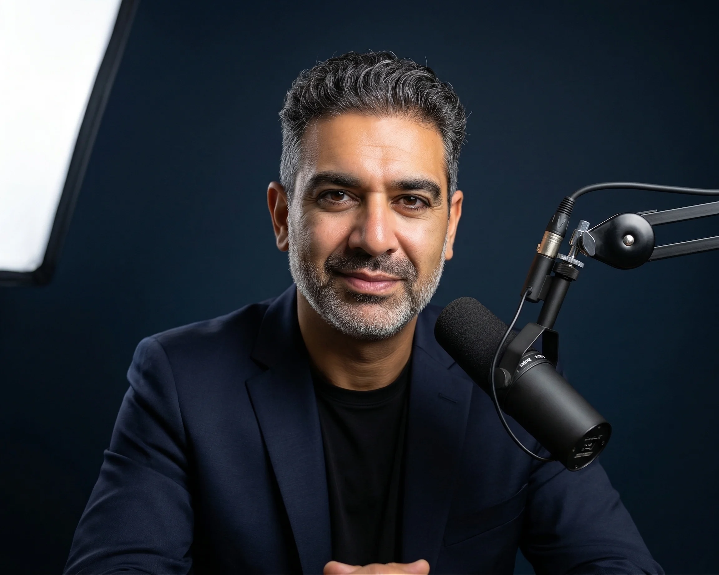 Moudy Elbayadi in a studio setting with a podcast microphone